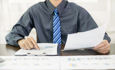 The business hand sits at their desks and calculates financial graphs showing the results of their investments planning the process of successful business growth