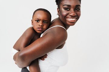 Black young woman laughing while playing and holding her son