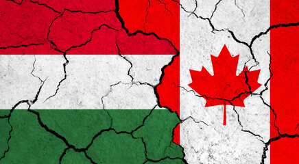 Flags of Hungary and Canada on cracked surface - politics, relationship concept