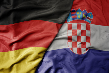 big waving realistic national colorful flag of germany and national flag of croatia .