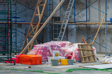 Building materials at the construction site. Building facade renovation. building materials are covered with a film from the rain