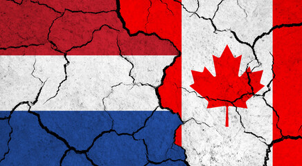 Flags of Netherlands and Canada on cracked surface - politics, relationship concept