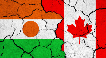Flags of Niger and Canada on cracked surface - politics, relationship concept