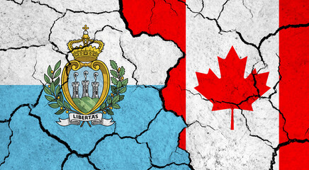 Flags of San Marino and Canada on cracked surface - politics, relationship concept