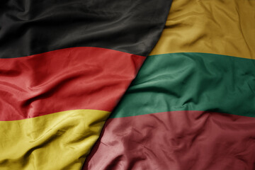big waving realistic national colorful flag of germany and national flag of lithuania .