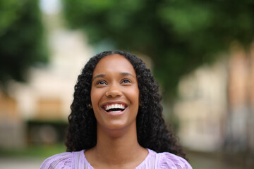 Black woman laughing looking up with white teeth
