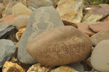 Buddhist mantra and stupa engraved over stone