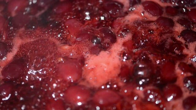 Mixing with a spoon, cooked cherry fruit jam in a pot. Mixing the cherries. 