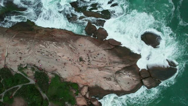 Topdown view of Famous Pedra do Arpoador, rocky peninsula with ocean waves crashing, Rio de Janeiro
