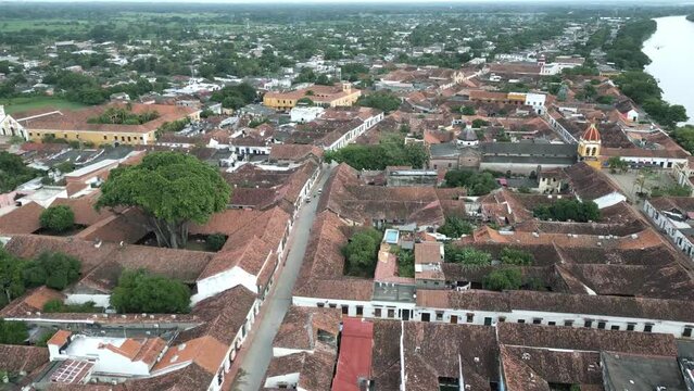 drone fly above historical city colonial architecture in Colombia santa cruz de mompox with river Magdalena