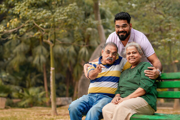 Young Indian man with his parents at park