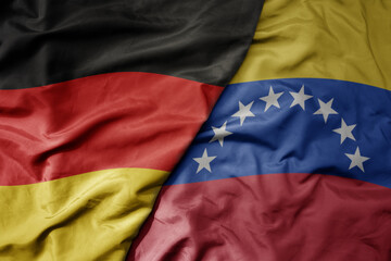 big waving realistic national colorful flag of germany and national flag of venezuela .