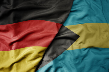big waving realistic national colorful flag of germany and national flag of bahamas .