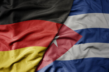 big waving realistic national colorful flag of germany and national flag of cuba .