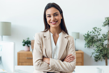 Beautiful elegant businesswoman looking at camera while standing in the office