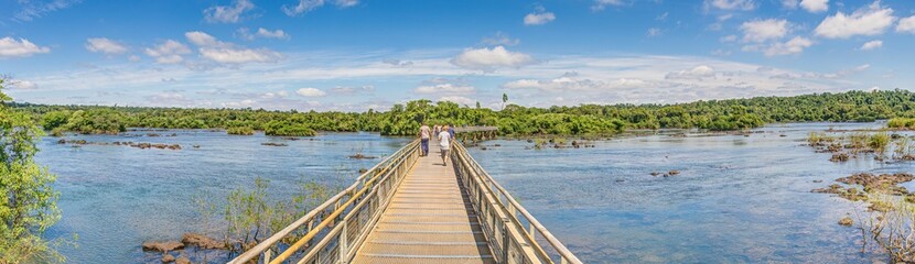 Obraz premium View along a wooden footbridge over a river at the Iguacu Falls in Brazil
