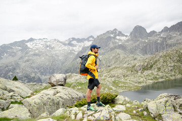 Young man standing on a rock with mountain background