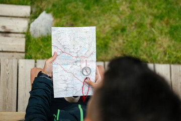 Unrecognizable man using map and compass