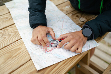 Close-up of man's hands using map and compass