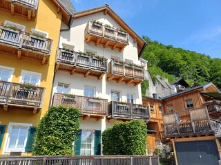 Fototapeta na wymiar Beautiful houses in sunny summer, on the mountainside of the Hallstatt town, Austria.