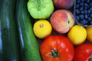 Wooden crate full of healthy colorful seasonal fruit and vegetable. Top view.