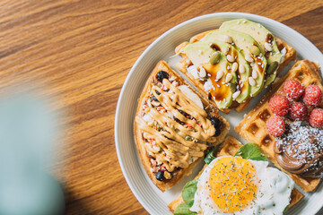 Homemade waffles with different toppings on a white plate.