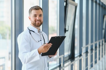 Portrait of handsome young doctor on hospital corridor