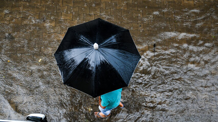 Women with black umbrella on a rainy day.  © RAYO CLICKS