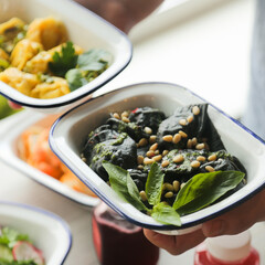 Black dumplings with pesto sauce