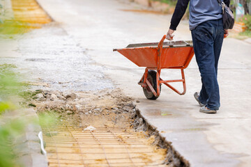 A builder on a trolley transports stones. Paving of pedestrian paths on city streets. 