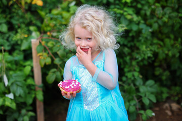 Cute little girl holding pink donut. 