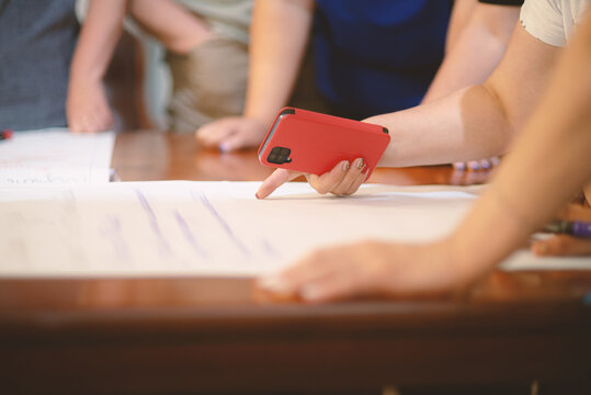 A team of people around a table are discussing what is written on paper.