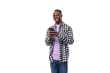 handsome young african man dressed in a plaid shirt talking on the phone