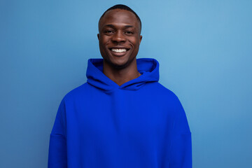 close-up portrait of a cute ethnic 25 year old african man in a stylish hoodie with a hood on a...