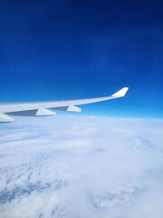 Abstract background of blue sky, white clouds and airplane wing