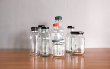 empty used glass bottle on wood desk. Recycle glass bottles and safe the earth concept. 