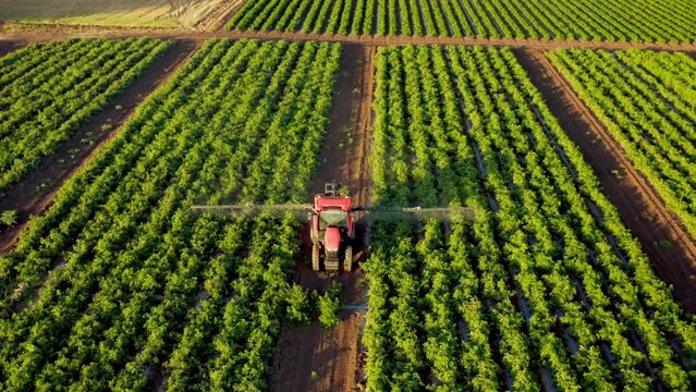 Agricultural machinery for leasing. Aerial view Agricultural sprayer tractor spraying pesticides turns around in farm land. Top down view