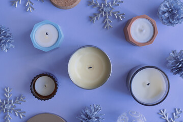 Soy candles and christmas decoration on blue background, top view. Winter season - 629488711