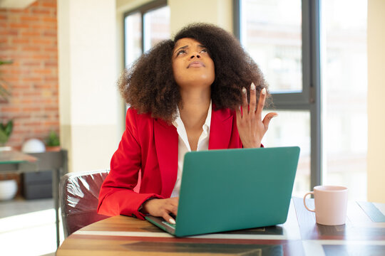 pretty afro black woman screaming with hands up in the air. businesswoman and laptop concept
