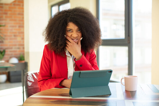 pretty afro black woman with mouth and eyes wide open and hand on chin. businesswoman and laptop concept