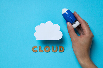 White paper cloud with a toy rocket and the word 
