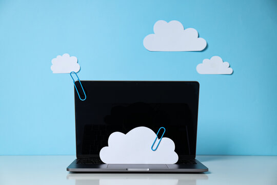 Laptop with paper clouds on a blue background