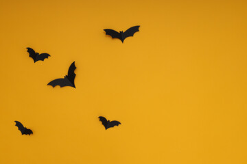Fototapeta premium Yellow background with black bats, in Halloween style