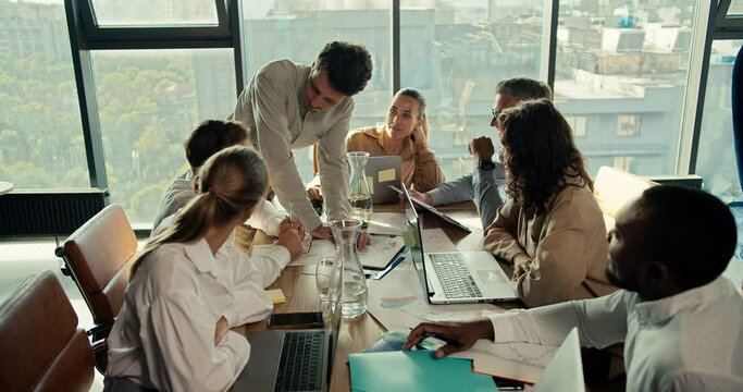 international team of office workers sit at the table and listen to the manager woman. Solving current problems at work