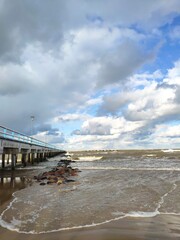 Winter beach with snow clouds and blue sky in day time