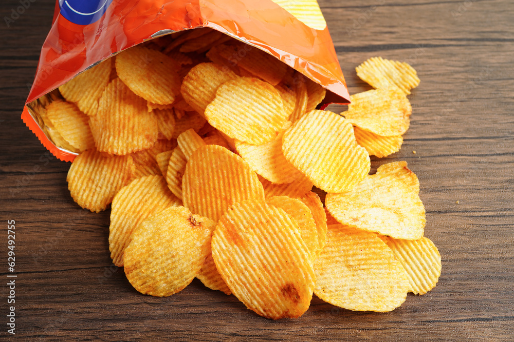 Wall mural potato chips in open bag, delicious bbq seasoning spicy for crips, thin slice deep fried snack fast 