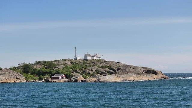 Stavernsodden Lighthouse Atop The Rocky Coastal Seen From Distance In Larvik, Norway. aerial