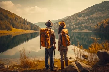 Foto op Canvas Back side of couple on the rock with hiking backpacks looking to beautiful landscape of epic view of mountains and lake. Generated Ai © MarijaBazarova