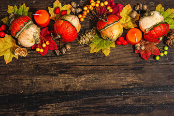 Autumn festive composition on old wooden background. Decorative pumpkin, fall leaves, berries,acorns