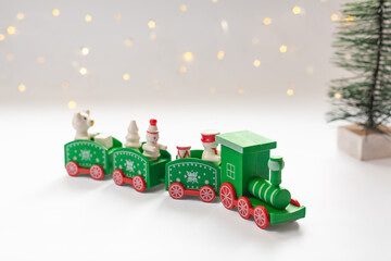 Green christmas train, fir tree and blurry bokeh lights in the background.